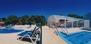 赞布热拉-杜马尔Camping Villa Park Zambujeira do Mar的一个带椅子的游泳池以及玻璃屋
