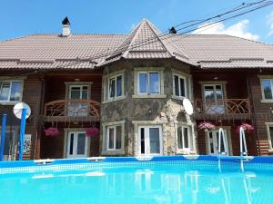 塔塔里夫Cottage Zhelikhovskykh的房屋前有游泳池的房子