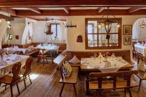 多瑙河畔诺伊堡祖斯特博瑞罗曼蒂克酒店的一间在房间内配有桌椅的餐厅