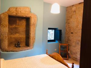 帕德隆Santiaguiño 2的一间卧室设有一张床和石墙