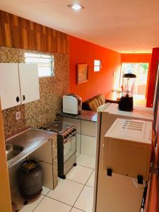 格拉瓦塔Casa em Gravata mobiliada的厨房设有橙色墙壁和炉灶烤箱