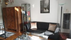 瓦尔滕贝格Appartement zum Entspannen的客厅配有黑色沙发和玻璃桌