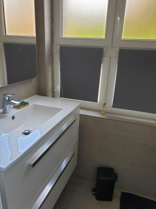 多维尔le castor的一间带白色水槽的浴室和两个窗户