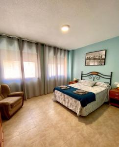 Casas del MonteAPARTAMENTO TURISTICO NAVALINDA的一间卧室配有一张床和一把椅子