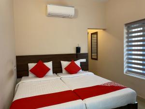 科泽科德La Mer Inn的一间卧室配有一张带红色枕头的大床