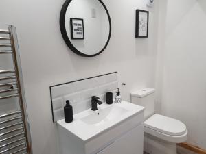 布恩The Snug Bourne的白色的浴室设有水槽和镜子
