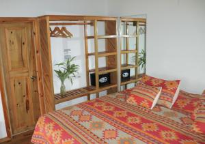 西湾Hotel Posada Seremein Roatan的一间卧室配有一张床和一个木制橱柜