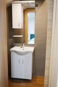蒂瓦特Apartmani M&E的浴室设有白色水槽和镜子