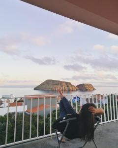 FeteiraApartamento Bela Vista Ilha Terceira的一位女士躺在俯瞰大海的阳台的椅子上