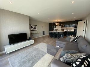 格拉斯哥Principal Apartments - Clyde Waterfront Apartments的客厅配有平面电视和沙发。