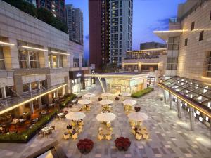 深圳深圳君悦酒店的享有带桌椅的庭院的顶部景致。
