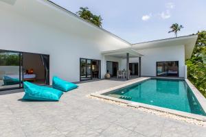 苏梅岛Villa Nirvana, 3 Bedrooms, Chaweng Noi的一个带游泳池和房子的后院