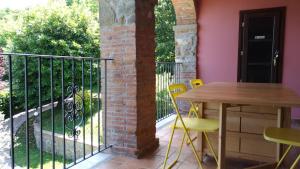 CamporgianoLa Collina dei Franchi的阳台配有桌椅和围栏。