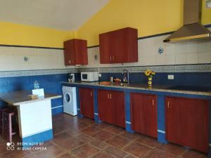 El Pinar del HierroCasa Rural El Pajar的厨房配有红色和蓝色的橱柜和洗碗机。