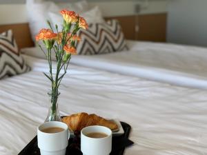 托尔尼奥托尔尼奥公园酒店的托盘,上面放着两杯咖啡和花瓶