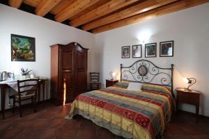 Montegalda法托瑞阿格利玛纳酒店的一间卧室配有一张床、一张桌子和一张桌子。