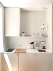 波尔图Guest House Arca d´'Água的白色的厨房配有白色橱柜和水槽