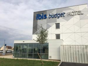 博韦ibis budget Beauvais Aeroport的一座白色的大建筑,上面有标志