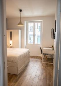 安锡Suite & Lake - Proche du Lac d'Annecy的一间卧室配有一张床、一张书桌和一个窗户。