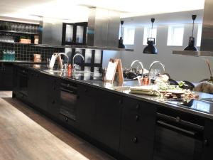 Marieberg东马尔马酒店的大型厨房配有大型黑色台面