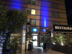 尼斯尼斯预卡娅音乐厅 -宜必思快捷酒店的建筑的侧面有蓝色的灯光