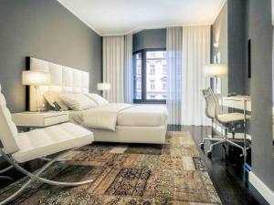 维也纳维也纳拉斐尔美居酒店的卧室配有白色的床、书桌和椅子