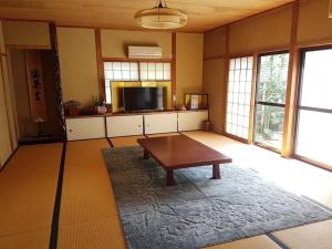 Kita-noda堺のお宿 旧星賀亭的客厅配有桌子和平面电视。