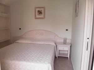 阿拉西奥Residence Panama的一间卧室配有一张床和一个带白色床罩的床头柜。