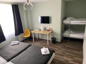 腓特烈港Hotel Capitol Zentrum - 24h -的客房设有两张床、一张书桌和双层床。