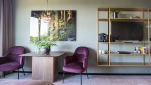 松兹瓦尔索德拉贝尔格特酒店的一间设有两张紫色椅子和一张桌子的房间