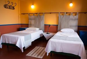 Pyrgi ThermisHotel Votsala的一间设有两张带白色床单的床的房间