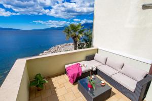 里耶卡诺拉别墅公寓的阳台配有沙发,享有海景。