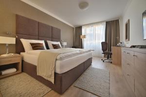 布拉迪斯拉发阿波罗布拉迪斯拉发大酒店的一间大卧室,配有一张大床和一张书桌
