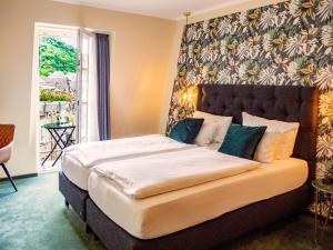 科赫姆哲迈尼尔酒店的一间卧室配有一张大床和大床头板
