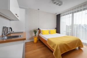 加茨比亚格拉帕丽奇公寓的一间卧室配有一张带黄色枕头和水槽的床