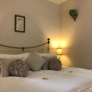 温莎公园农场酒店的卧室配有带枕头和灯的白色床