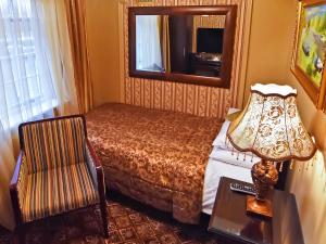 伊利Riverside Inn的一间卧室配有一张床、镜子和椅子