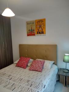 巴耶杜帕尔CH3 Moderno apartamento amoblado en condominio RNT-1O8238的一间卧室配有一张带两个红色枕头的床