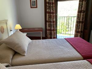 卡皮雷拉Hostal Atalaya en Capileira CB的一间卧室设有一张床和一个阳台的窗户。