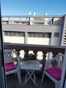 里耶卡Soba Marinko的阳台配有两把椅子和一张桌子,阳台与大楼相连