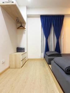 马六甲Amadel Residence 爱媄德民宿 13的一间卧室配有床和蓝色窗帘
