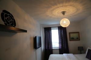 Vingåker威加客酒店的一间卧室设有一张床、一个窗户和一个吊灯。