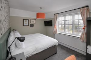 锡德茅斯Balfour Arms的卧室配有白色的床和窗户。