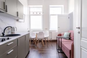 考纳斯River house apartments的厨房配有粉红色的沙发和桌子