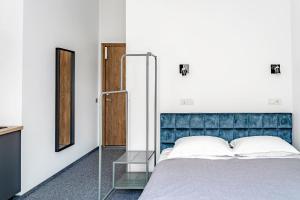 考纳斯River house apartments的一间卧室配有一张带蓝色床头板和镜子的床