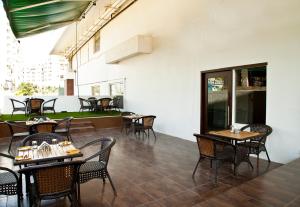 班加罗尔奥克塔夫Spa酒店 - 萨加普尔路店的庭院内的餐厅,配有桌椅