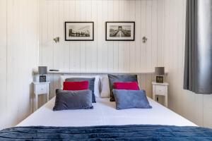 昂贝略昂比热Les minis homes du Bugey - Eco-lodge City, un refuge en hyper centre的一间卧室配有一张带红色和蓝色枕头的大床