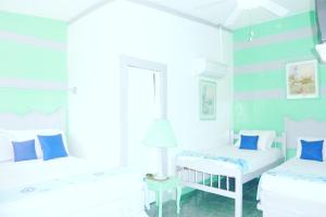 马萨亚伊万尼亚酒店的白色客房的两张床,拥有蓝色的墙壁