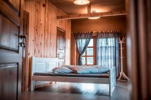 LīvāniBrīvdienu māja "Avotiņš"的木制客房的一张床位,设有窗户
