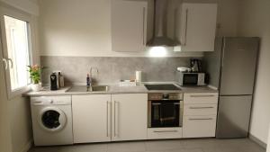 哈姆Melia的厨房配有白色橱柜、水槽和洗碗机。